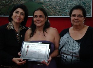 As vereadoras Maurilia Landim e Cida Armani entregam a placa em homenagem ao Jornal O Guaíra