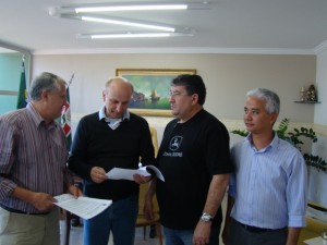 Presidente da Câmara, José Mendonça, faz a entrega de documento ao diretor da Predilecta, José Reinaldo, observado pelo secretário Sérgio Suzuki e o prefeito José Carlos