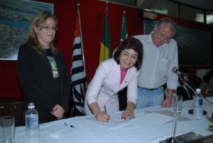 A vereadora Maurilia Landim assina convênio ao lado do prefeito José Carlos e da representante da Brejeiro Micheli