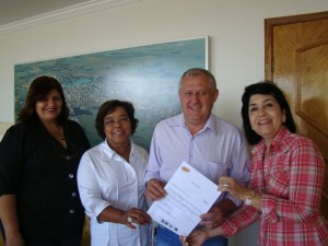 A vereadora Maurília Landim faz a entrega da carta de crédito do Reviva o Óleo ao prefeito José Carlos, primeira dama Edna e assistente social Eliana
